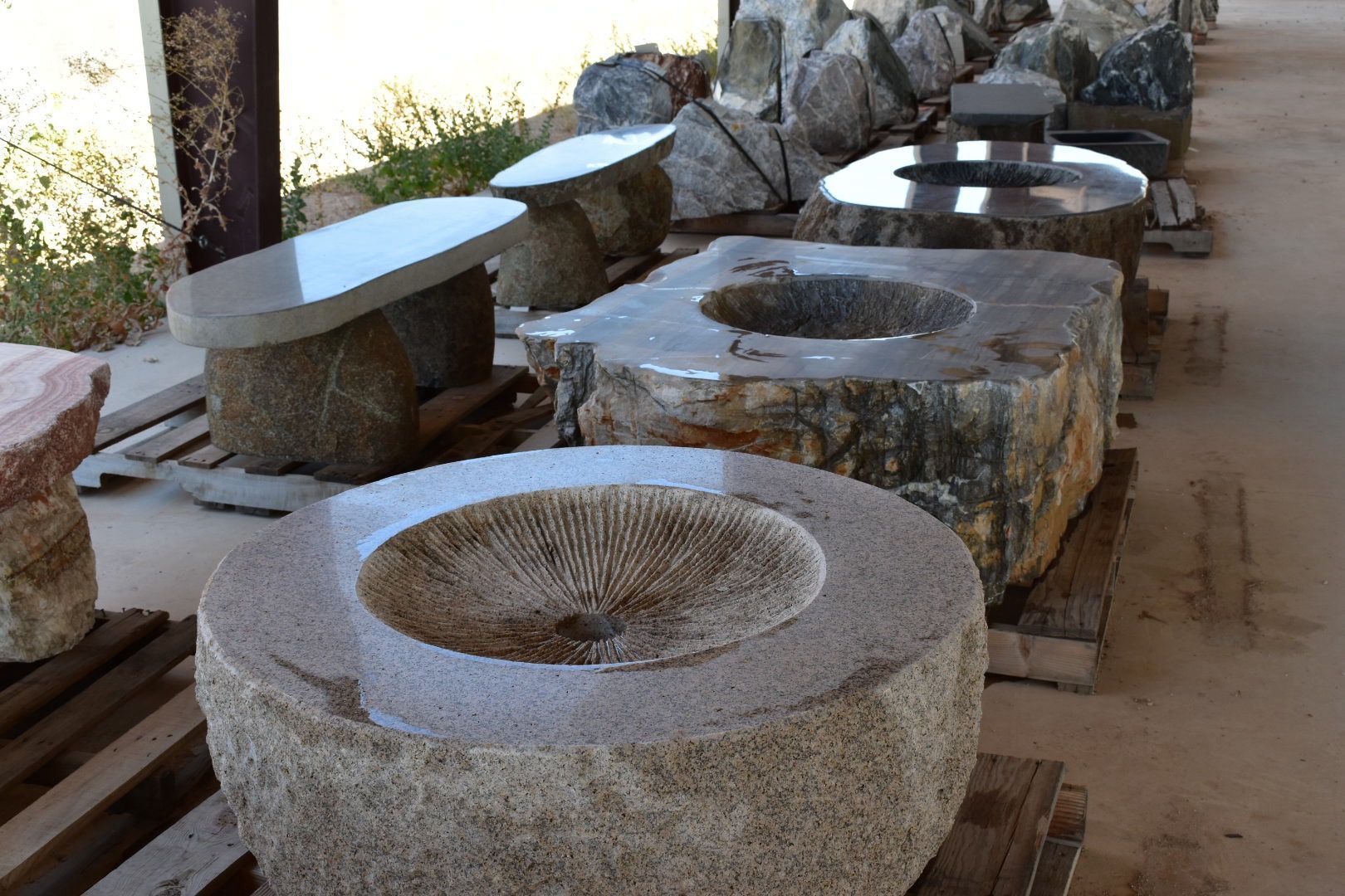 A row of stone sculptures sitting on wooden pallets