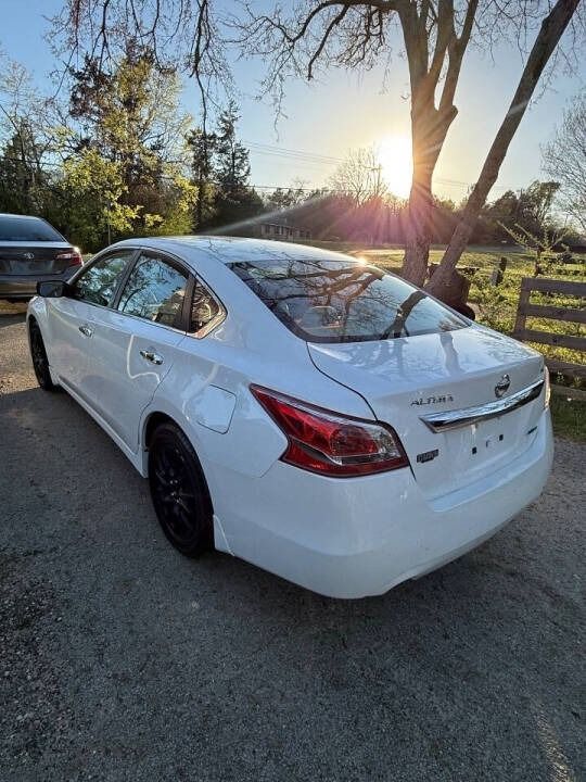White sedan parked on a roadside at sunset, with trees and a fence in the background.