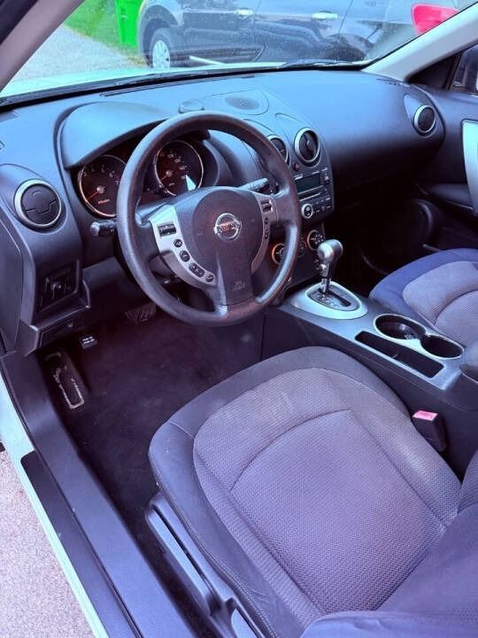 Interior of a compact car, showing the steering wheel, dashboard, front seats, and center console.