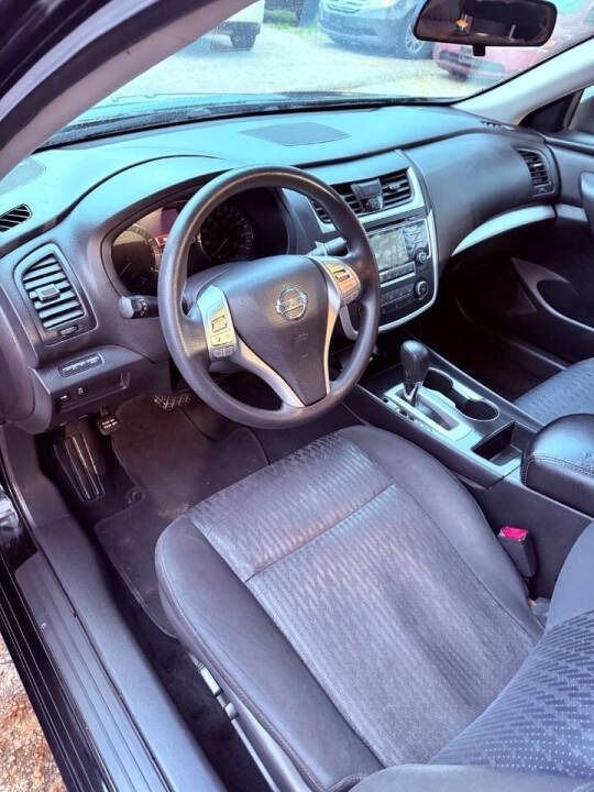 Car interior with black dashboard, leather seats, and steering wheel, viewed from the driver’s side.