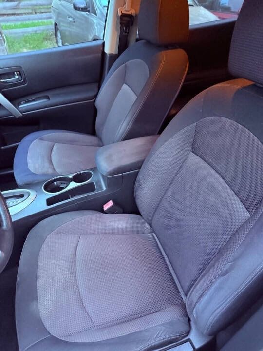 Car interior with two gray cloth front seats and center console with cup holders and armrest