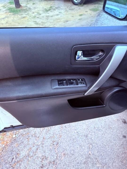 Car door interior with handle, power window controls, and storage pocket visible.