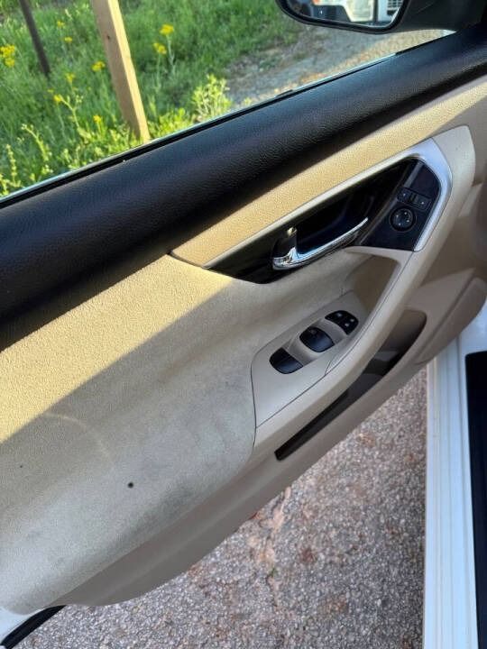Beige car interior door panel with window controls and chrome handle, viewed from the open door
