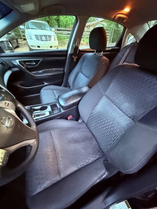 Car interior with gray cloth seats, steering wheel, and center console, viewed from the driver’s side