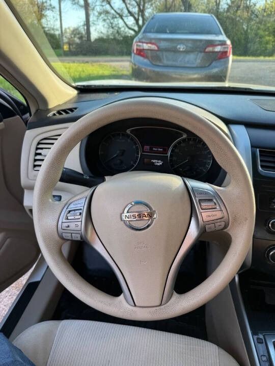 Driver’s view of a Nissan steering wheel and dashboard, with a car stopped behind ahead on a road.