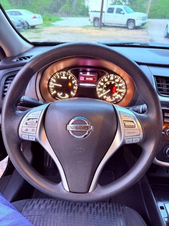 Nissan steering wheel and illuminated dashboard viewed from the driver’s seat, with parked vehicles visible ahead