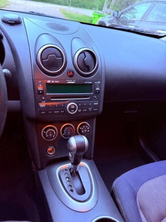 Car dashboard and center console with radio, climate controls, and automatic gear shift.