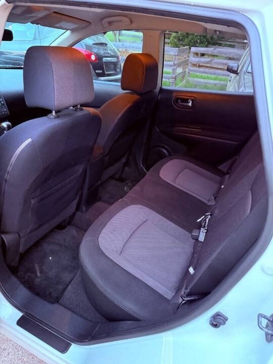 Car interior with two gray rear seats and open rear door, viewed from outside