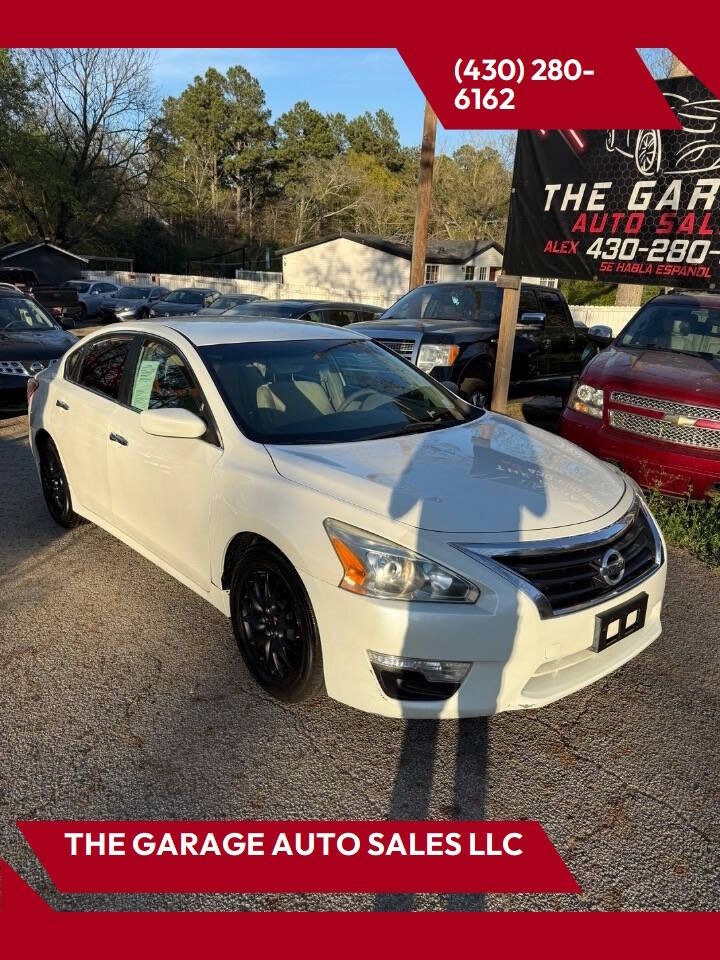 White Lexus sedan with black wheels at The Garage Auto Sales LLC car lot, with red dealer signage.