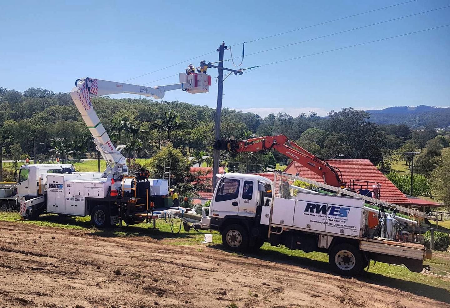 Two Utility Trucks With Workers Repairing a Power Line — Rob Ward Electrical Services in Ballina, NSW