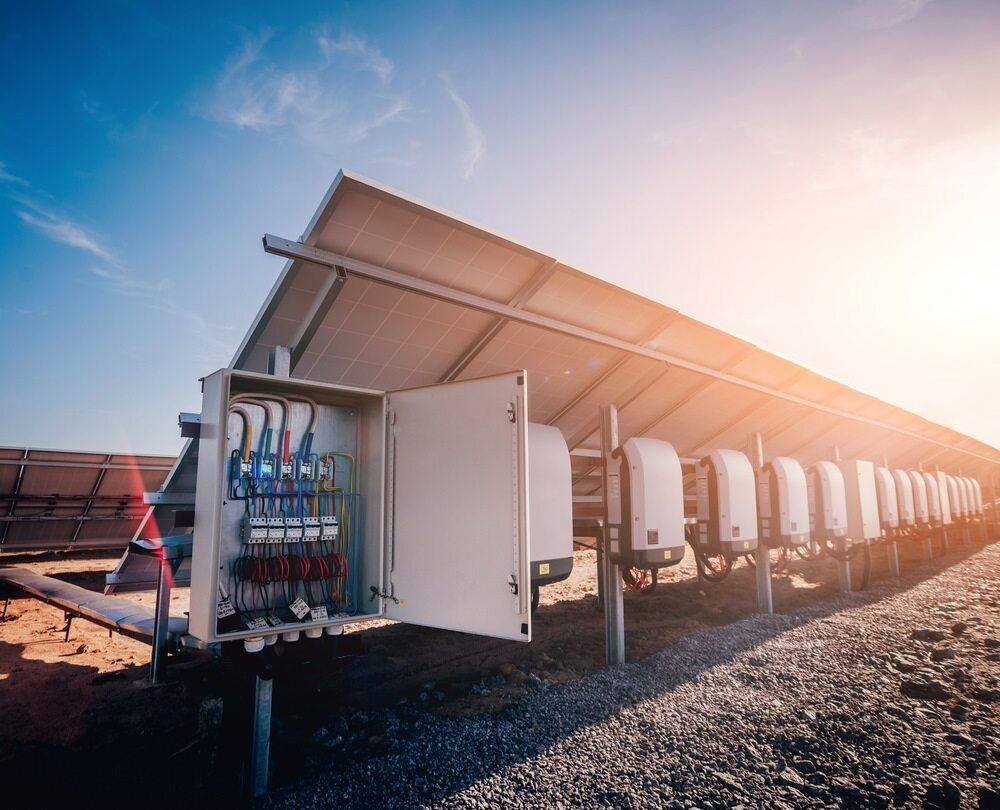 A Row of Solar Panels Sitting on Top of a Dirt Field — Rob Ward Electrical Services in Byron Bay, NSW