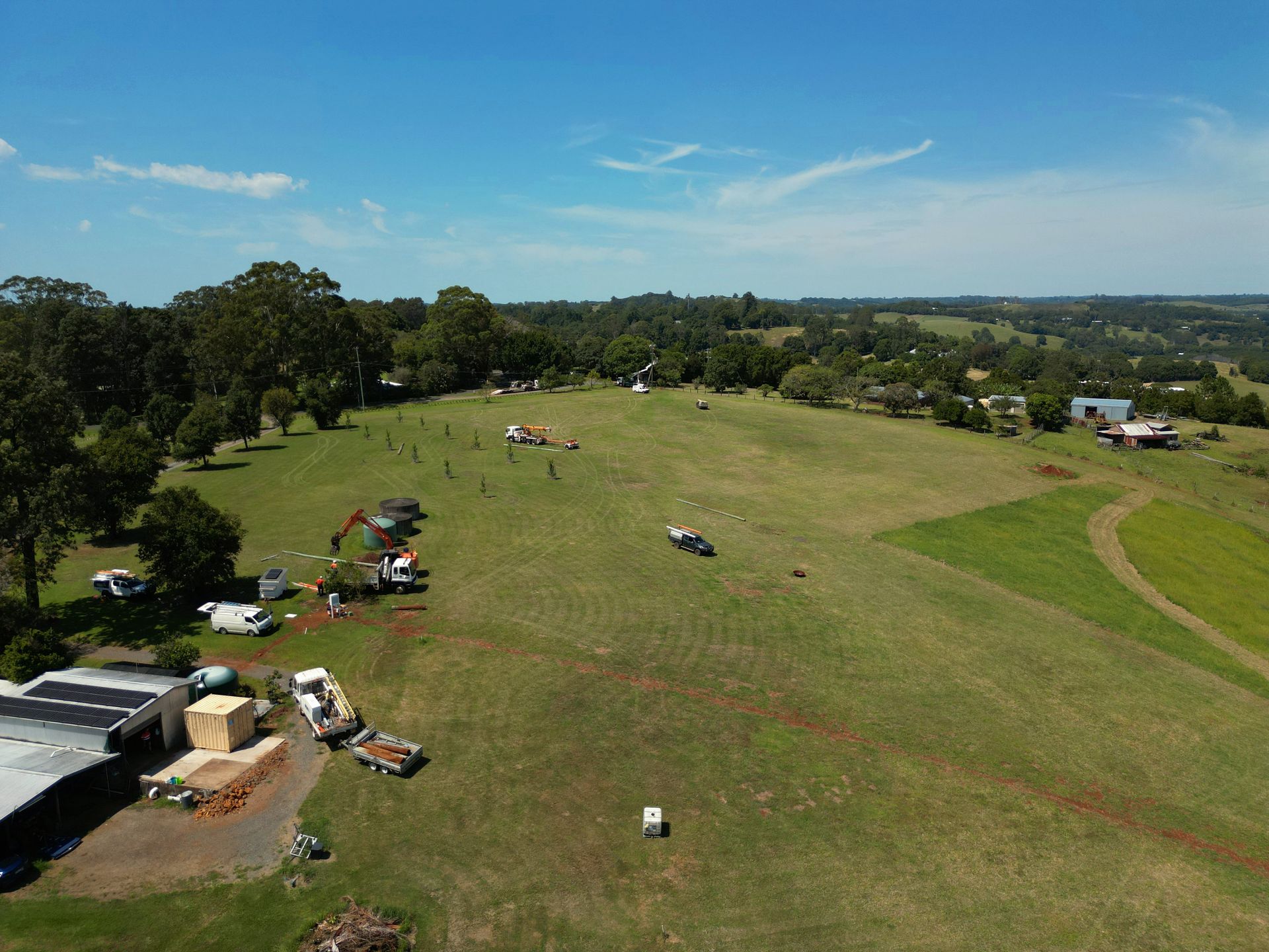 Green Hillside With Vehicles and People — Rob Ward Electrical Services in Wardell, NSW