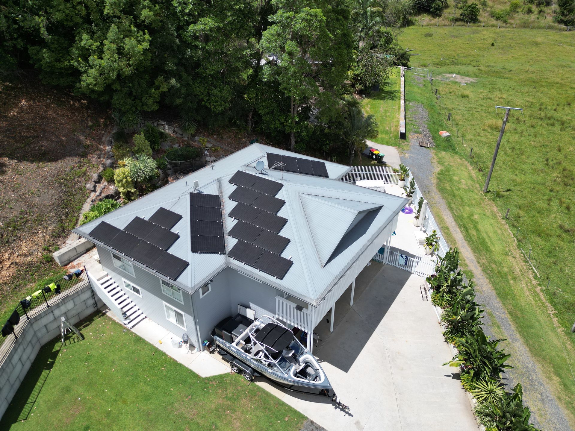 House With Solar Panels on a Hillside — Rob Ward Electrical Services in Broadwater, NSW