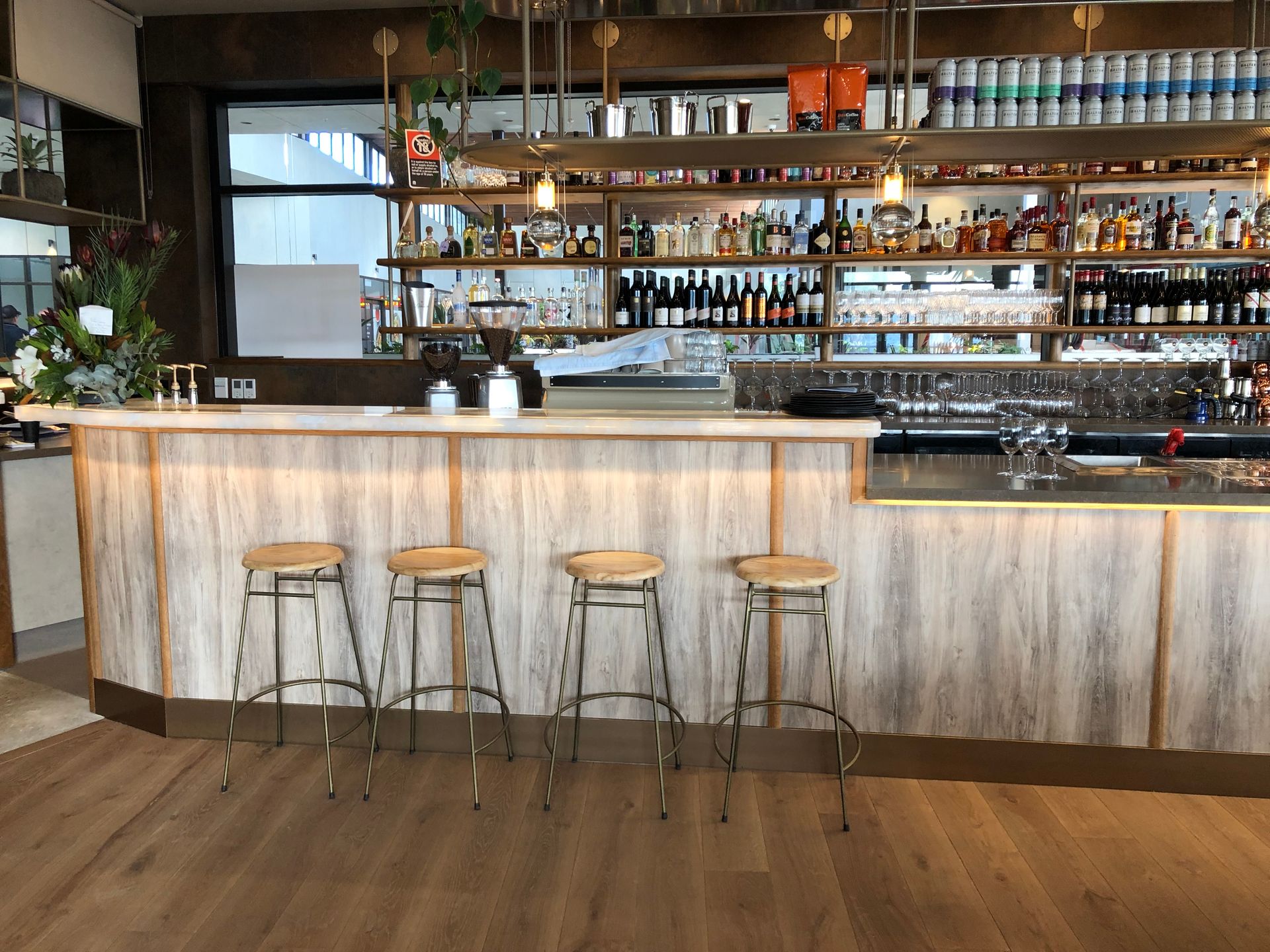Bar With Wood Paneling, Stools, and Shelves Stocked With Bottles — Rob Ward Electrical Services in Wardell, NSW