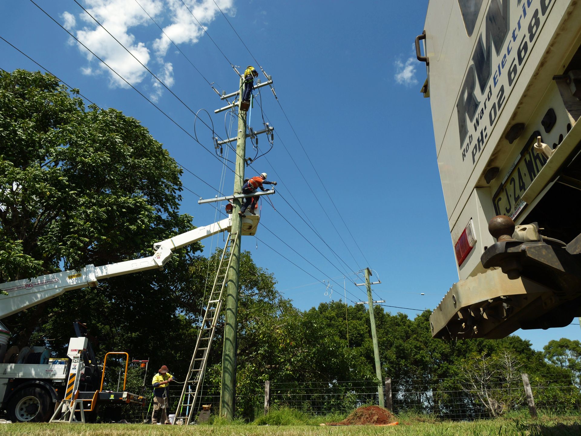 Linemen in a Bucket Truck Working on Power Lines — Rob Ward Electrical Services in Lennox Head, NSW