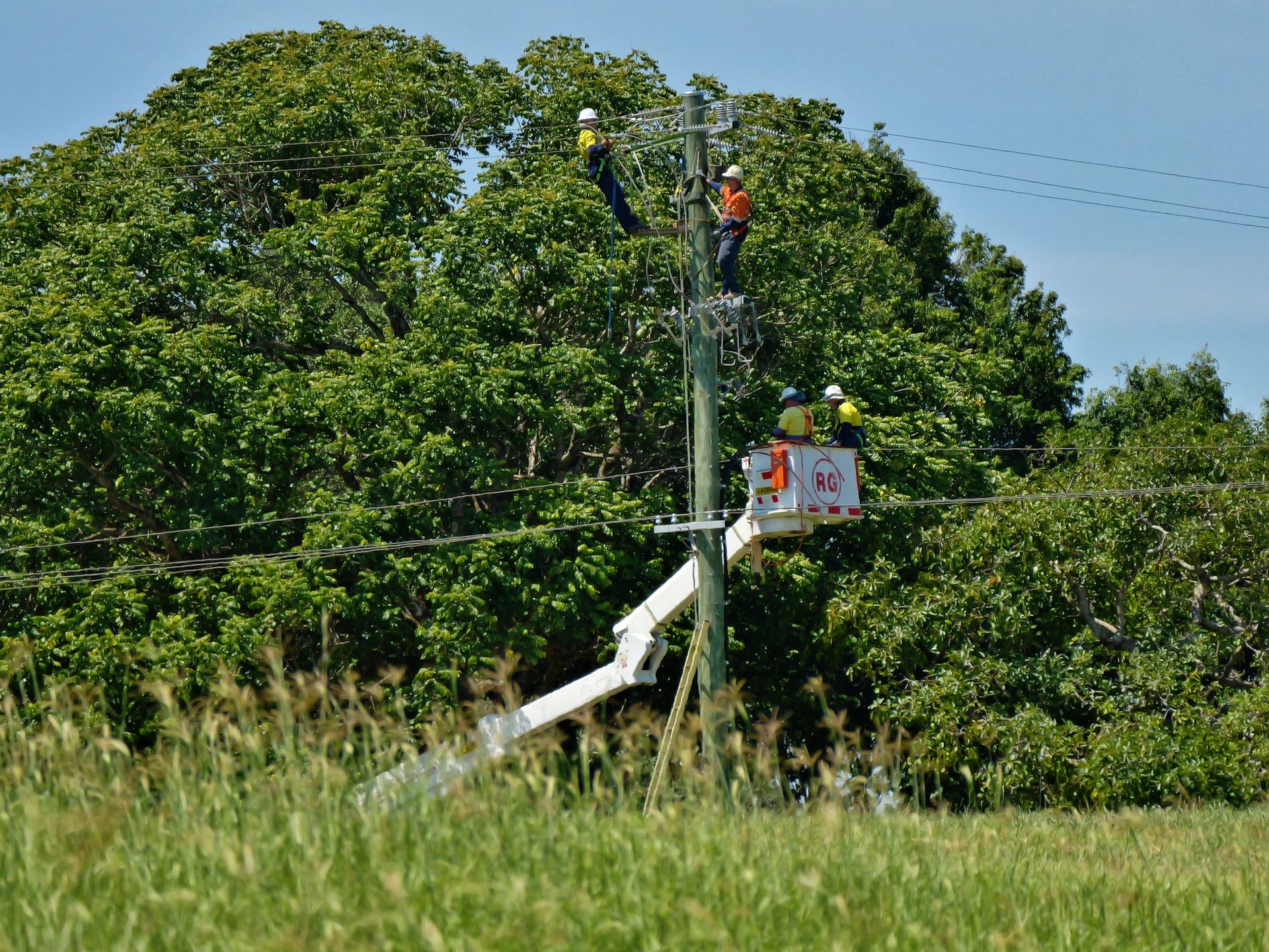 Linemen on Utility Pole With Lift — Rob Ward Electrical Services in Wollongbar, NSW