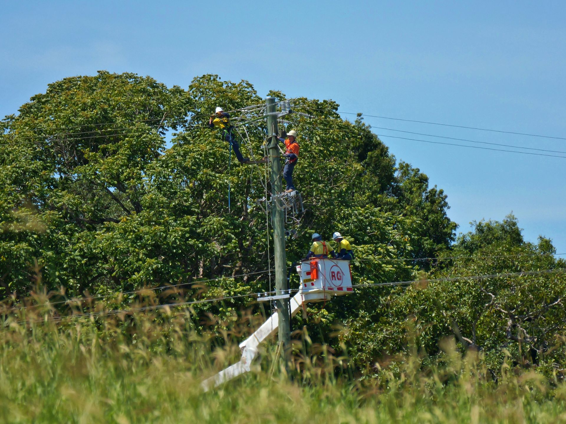Linemen in Orange Vests on Power Pole, Using a Bucket Truck, — Rob Ward Electrical Services in Mullumbimby, NSW