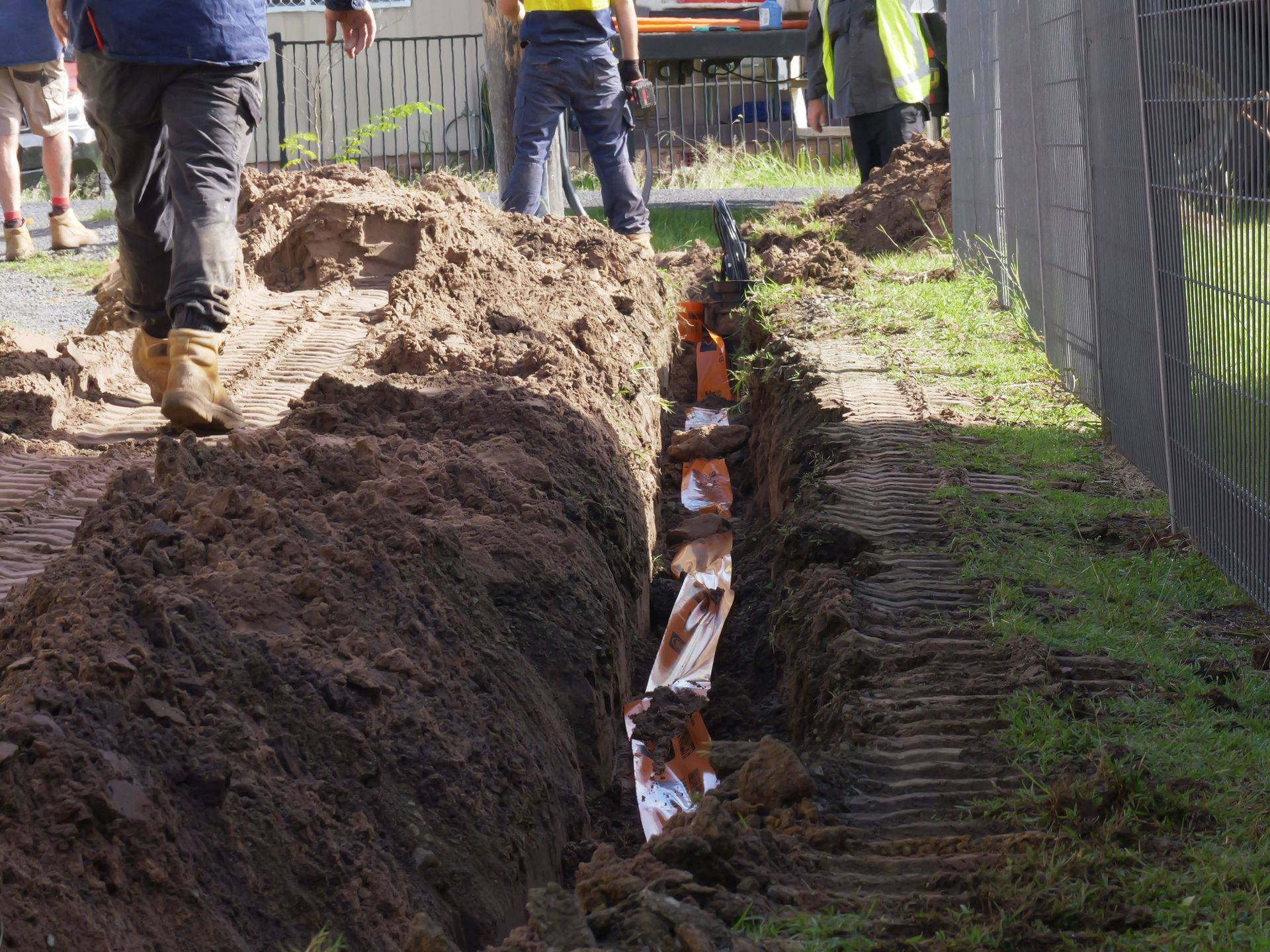 Trench Dug in the Ground With Exposed Orange Pipes. — Rob Ward Electrical Services in Byron Bay, NSW