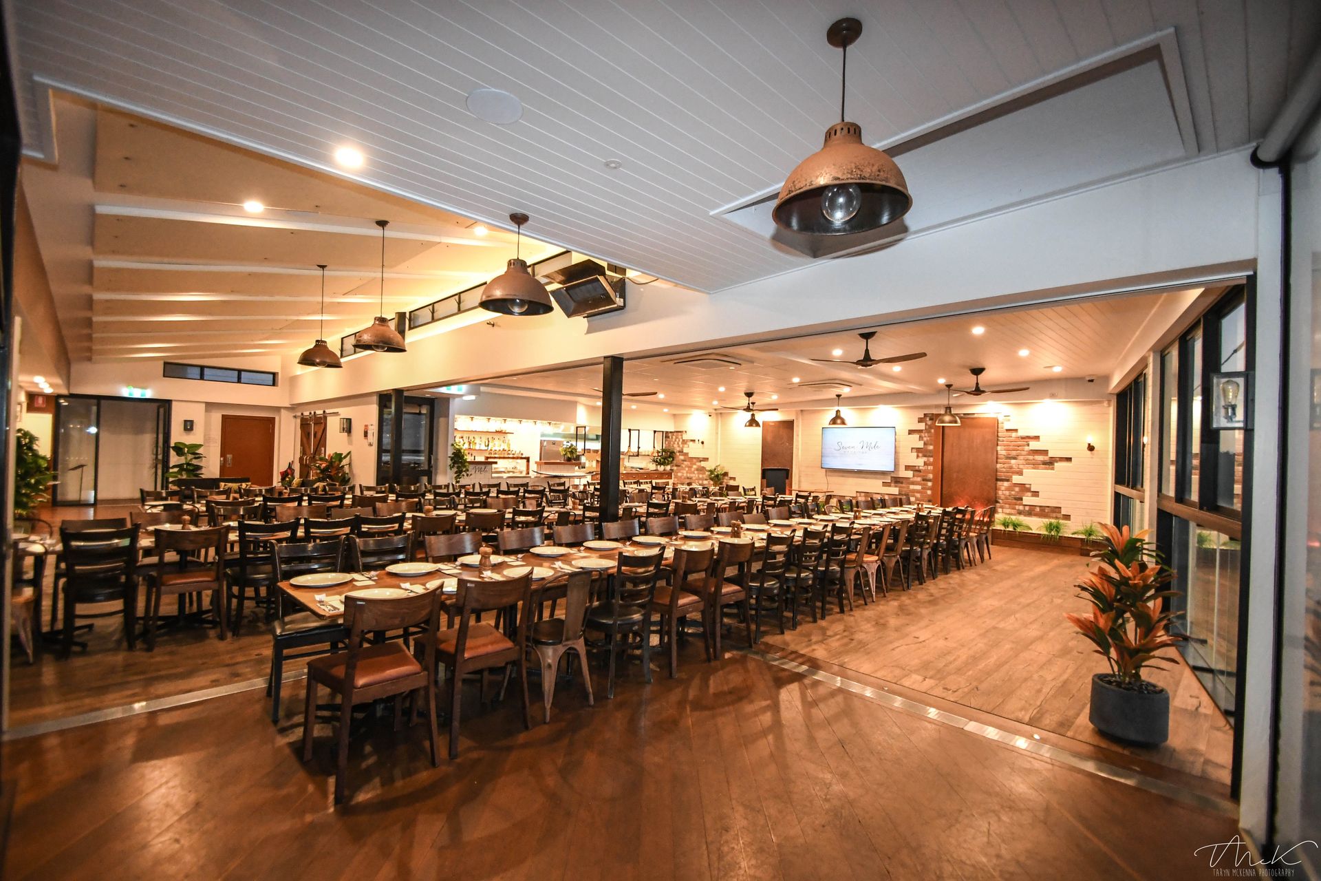 Dining Room With Long Tables, Dark Chairs, and Overhead Lighting — Rob Ward Electrical Services in Lismore, NSW