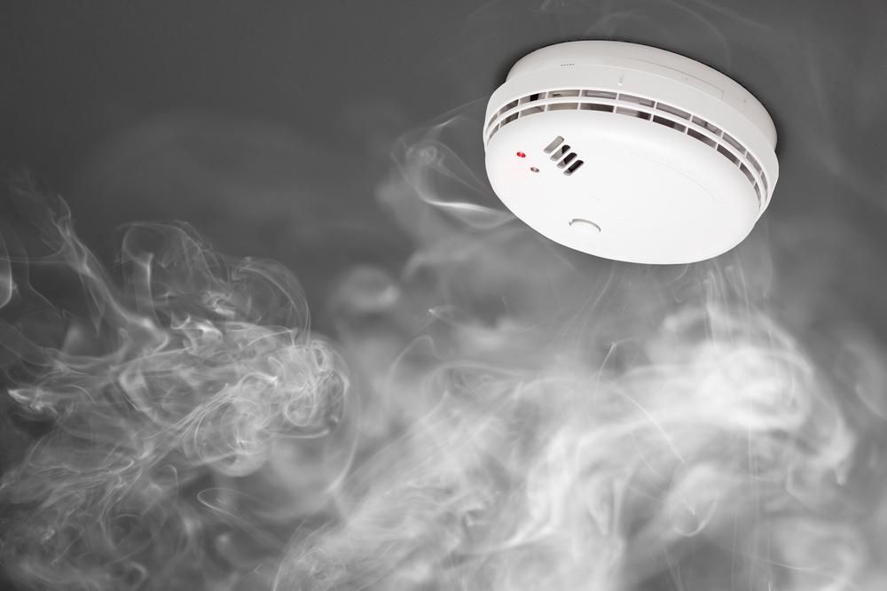 A Smoke Detector is Surrounded by Smoke Coming Out of It — Rob Ward Electrical Services in Wollongbar, NSW