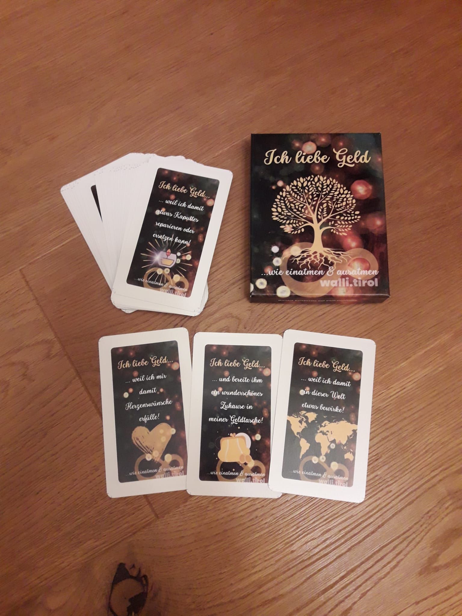 Eine im Tarot-Stil ausgelegte Kartenanordnung auf einem Holztisch, wobei eine größere illustrierte Karte und mehrere kleinere Karten darum herum angeordnet sind.