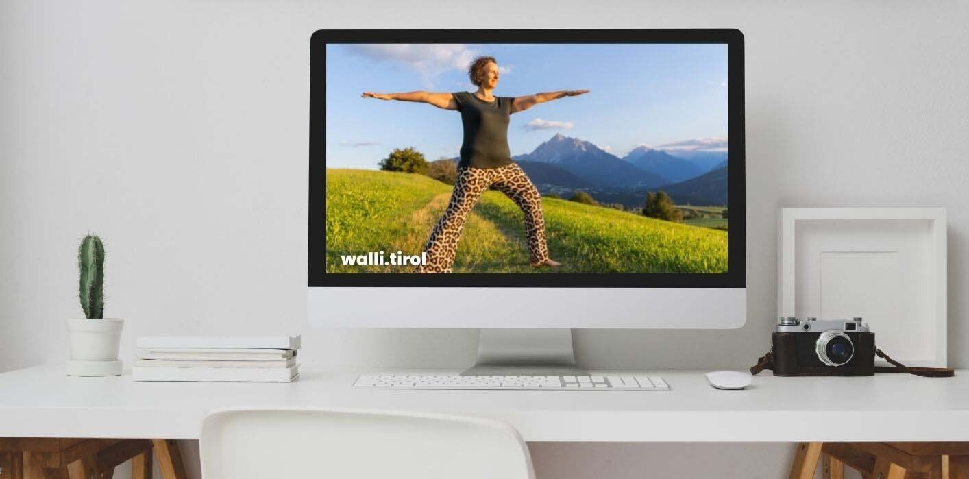Desktop-Computer auf einem weißen Schreibtisch, auf dem eine Person bei einem Workout in einem sonnigen Feld zu sehen ist.