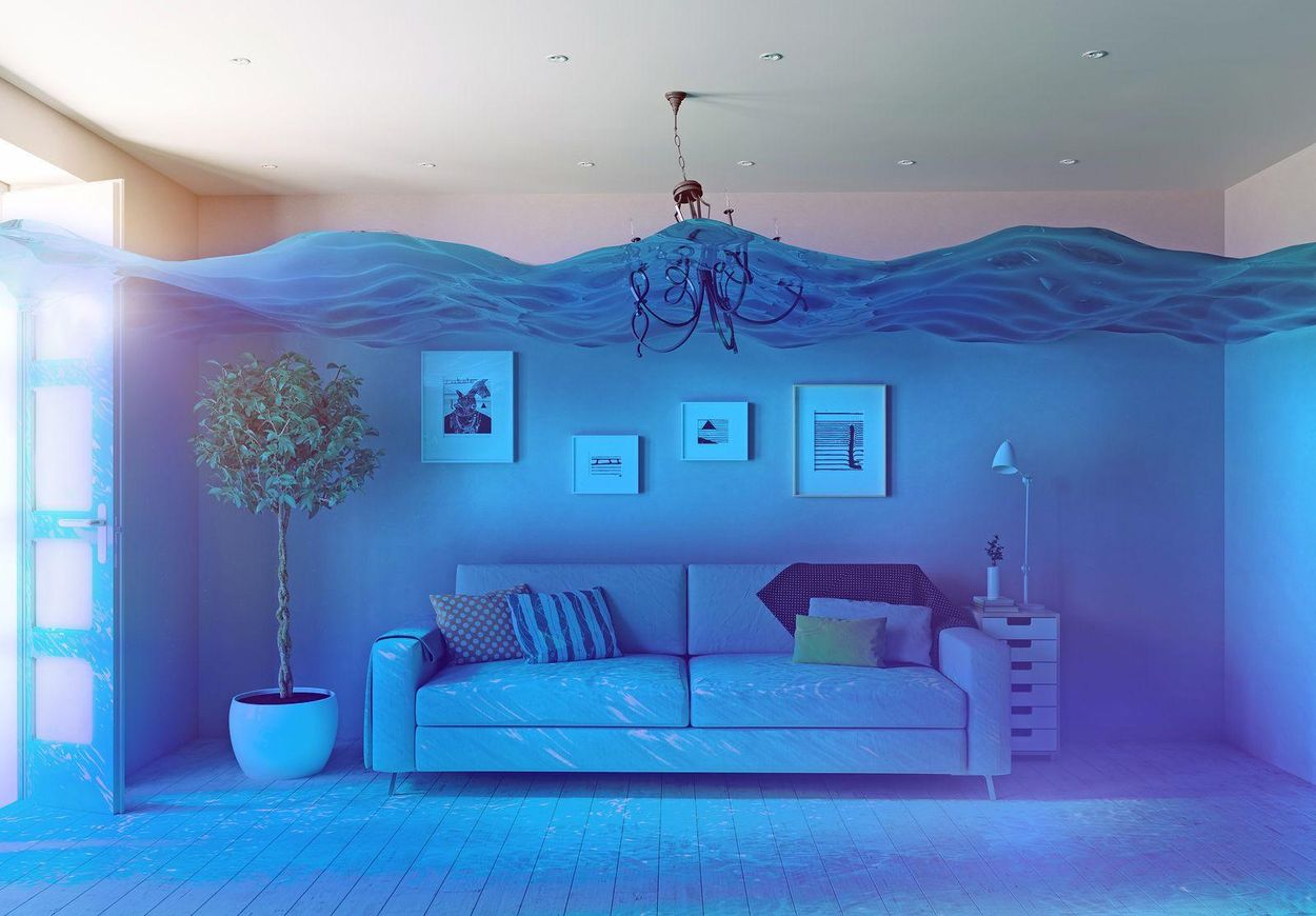 Living room flooded with water; couch, pictures on wall, and chandelier are partially submerged.