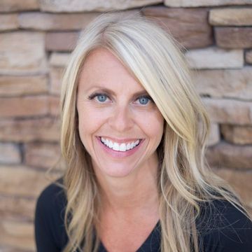 Top family dentist in Lee's Summit, MO and surrounding areas. A woman is smiling in front of a stone wall.