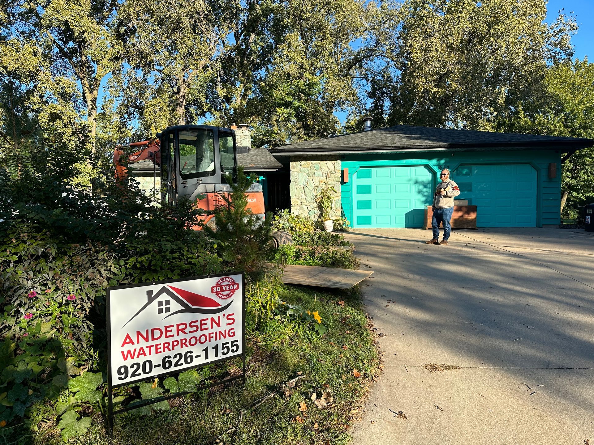 A sign for andersen 's waterproofing is in front of a house.