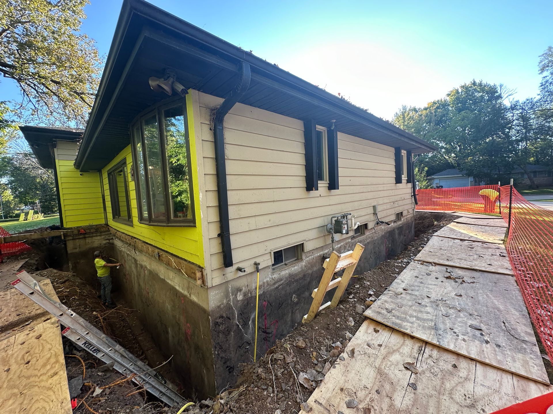 A house with yellow siding is being remodeled.