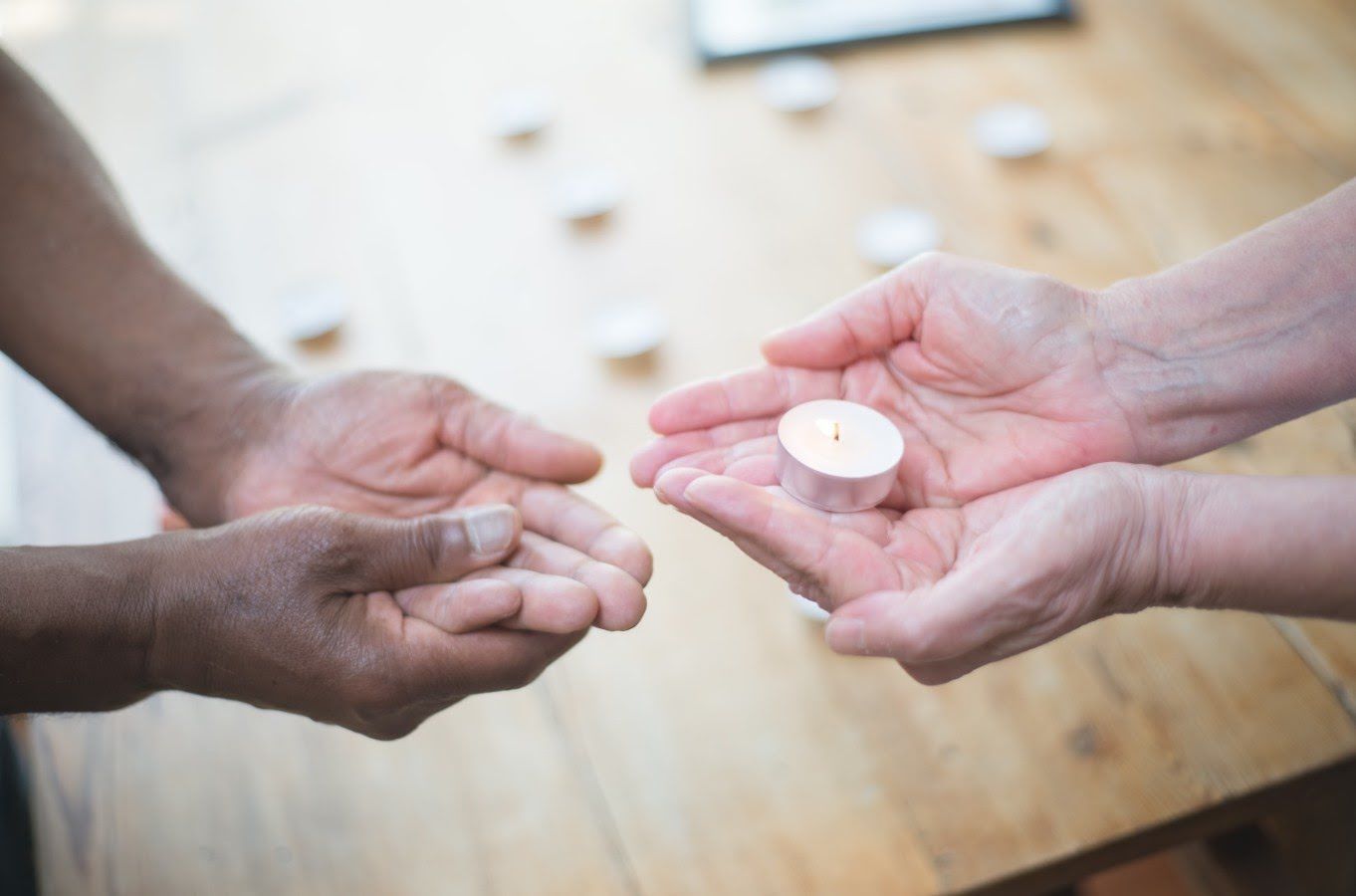 Hands sharing a memorial candle during compassionate funeral care in Palmetto, FL