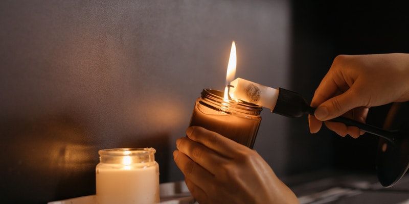Hands lighting a memorial candle in a peaceful funeral home setting in Bradenton, FL
