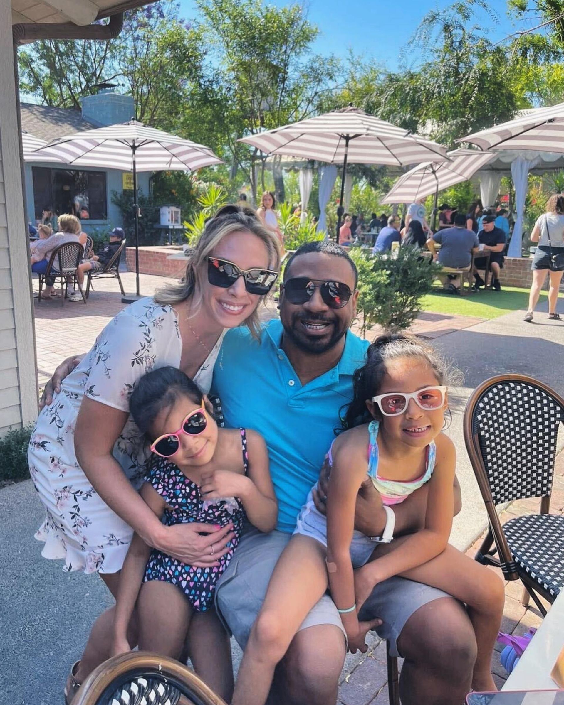 A family is posing for a picture while sitting at a table.