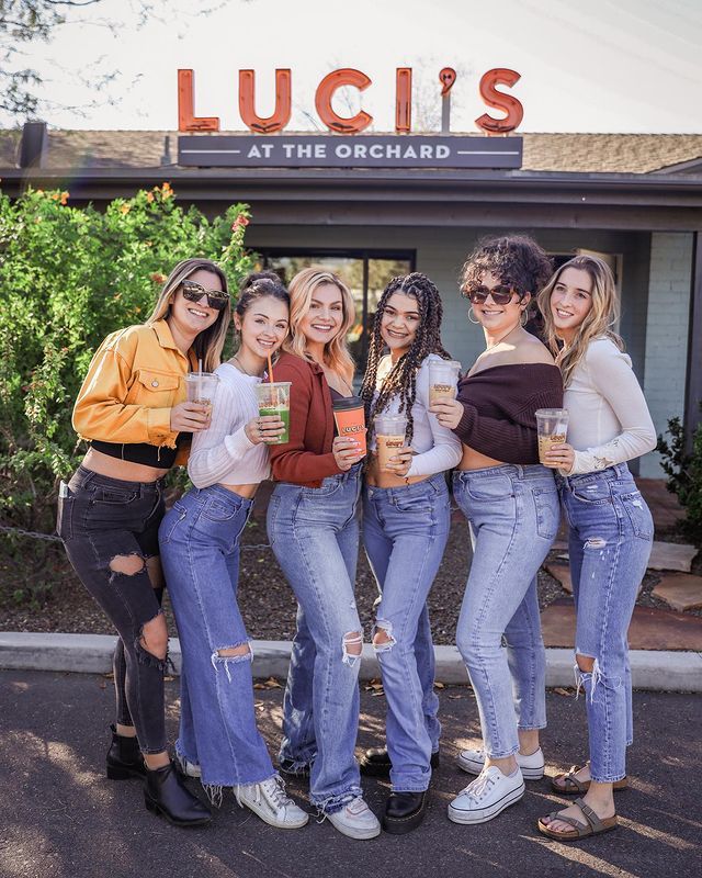 A group of women are posing for a picture in front of a restaurant.