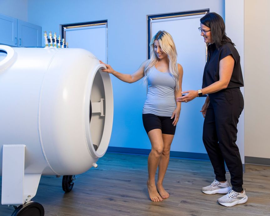 Two women are standing next to each other in front of a machine.