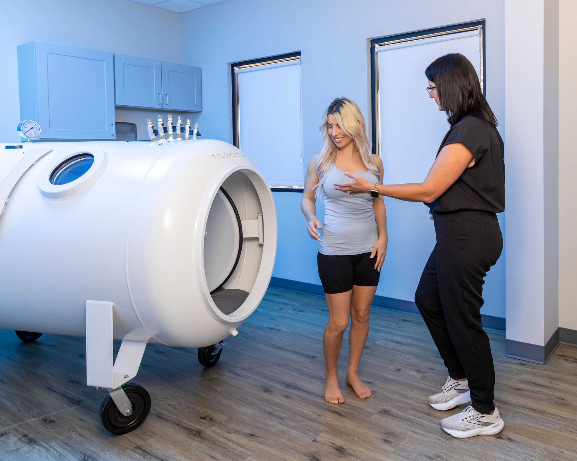A woman is standing next to a woman in front of a machine.