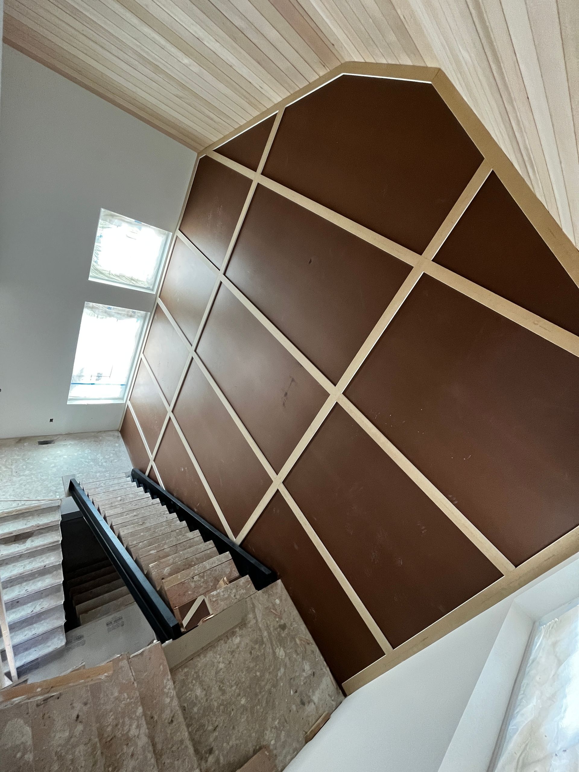 A staircase with a wooden ceiling and a wooden railing