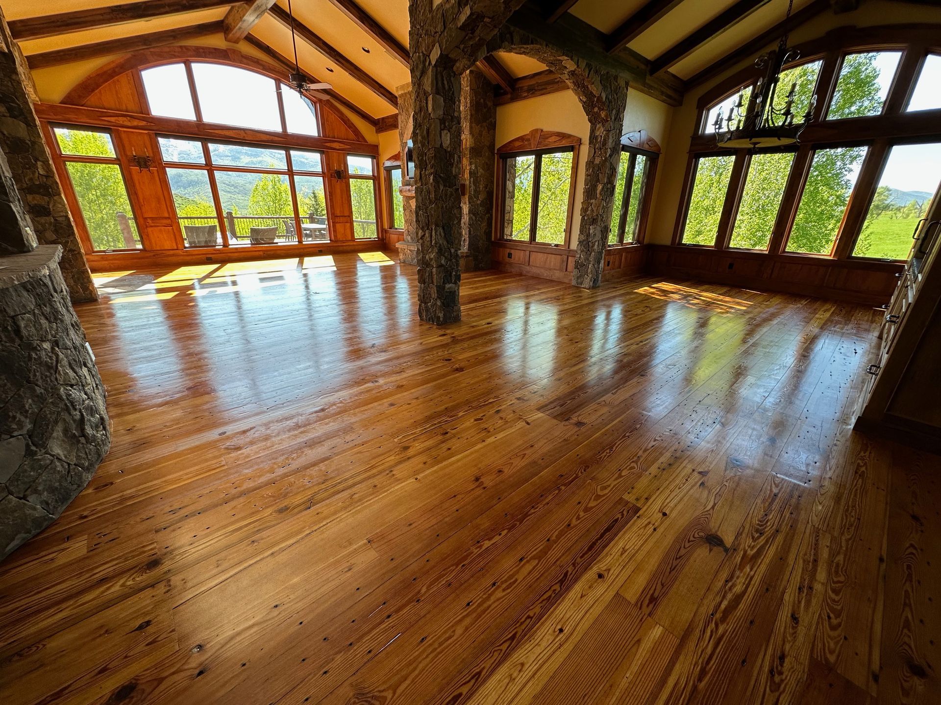 A large room with wooden floors and lots of windows