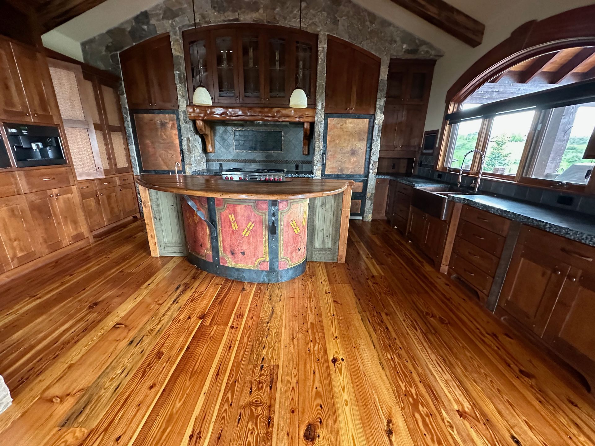 A kitchen with hardwood floors and a large island in the middle.