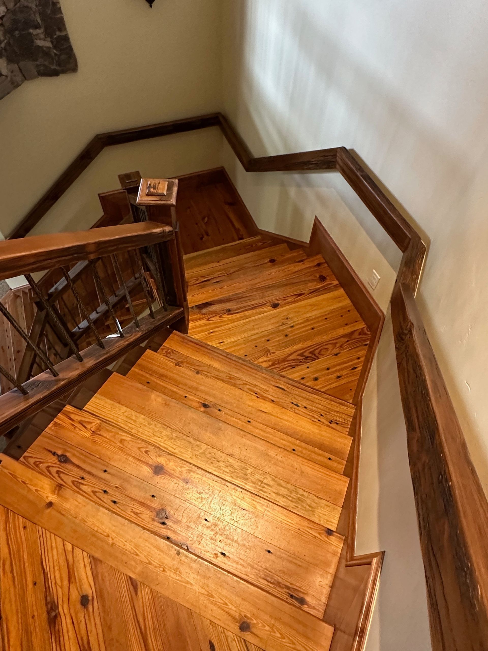 A wooden staircase with a glass railing leading up to the second floor.