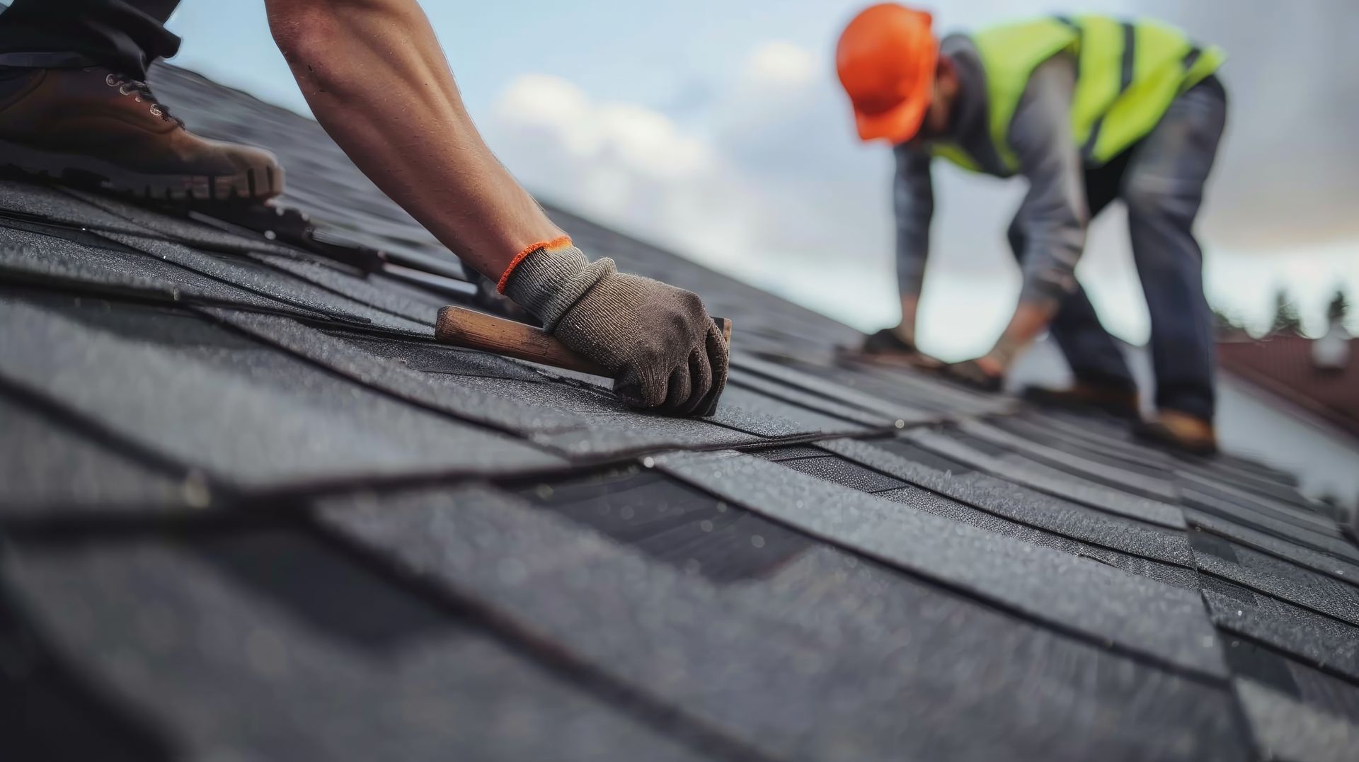 Roofing contractors installing shingles on a residential roof. Roofing contractors installing shingles on a residential roof.