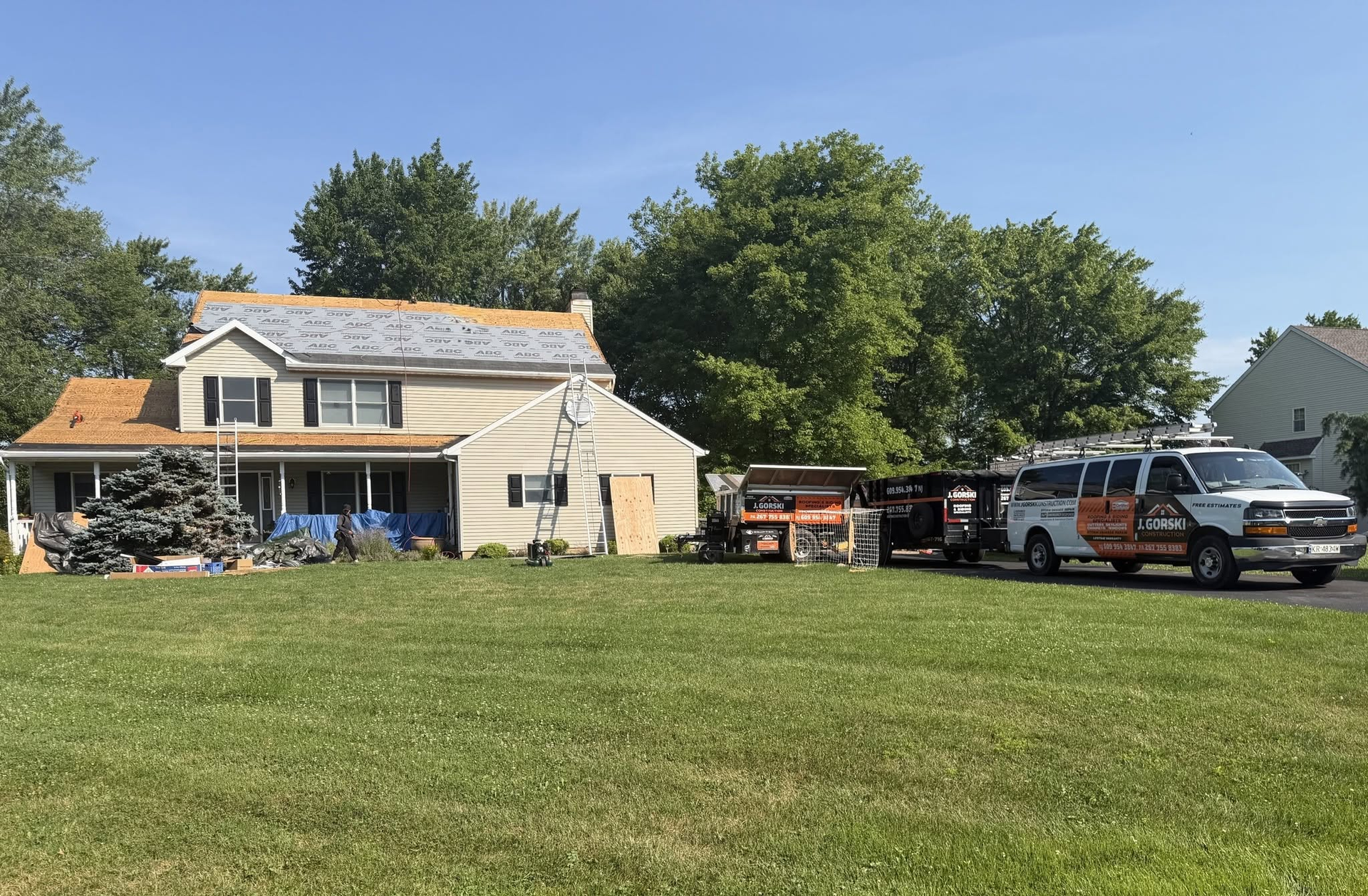 Workers fixing roof against blue sky, showcasing roofing services, installing shingles. Workers fixing roof against blue sky, showcasing roofing services, installing shingles.