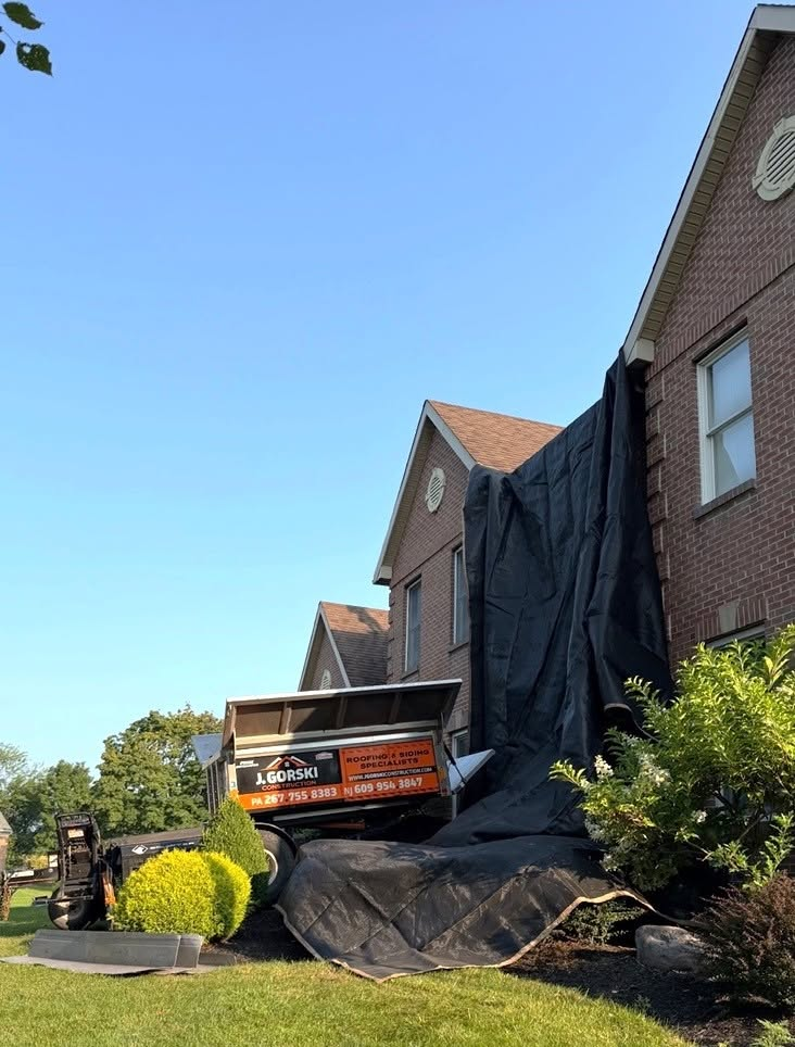 A roof replacement contractor replaces the clay tile roof covering of a home.