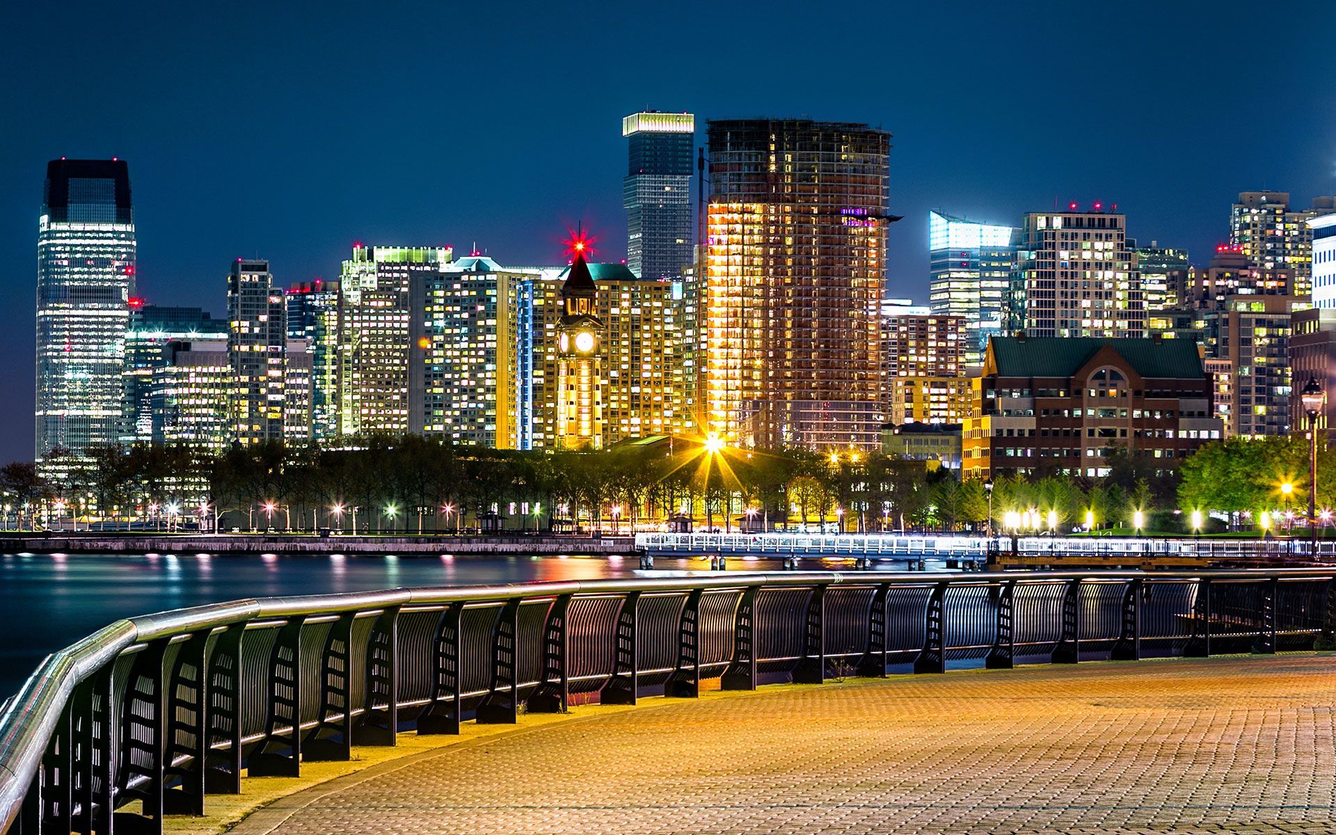 Buildings along the waterfront, and a foreground with a curved walkway and fence.