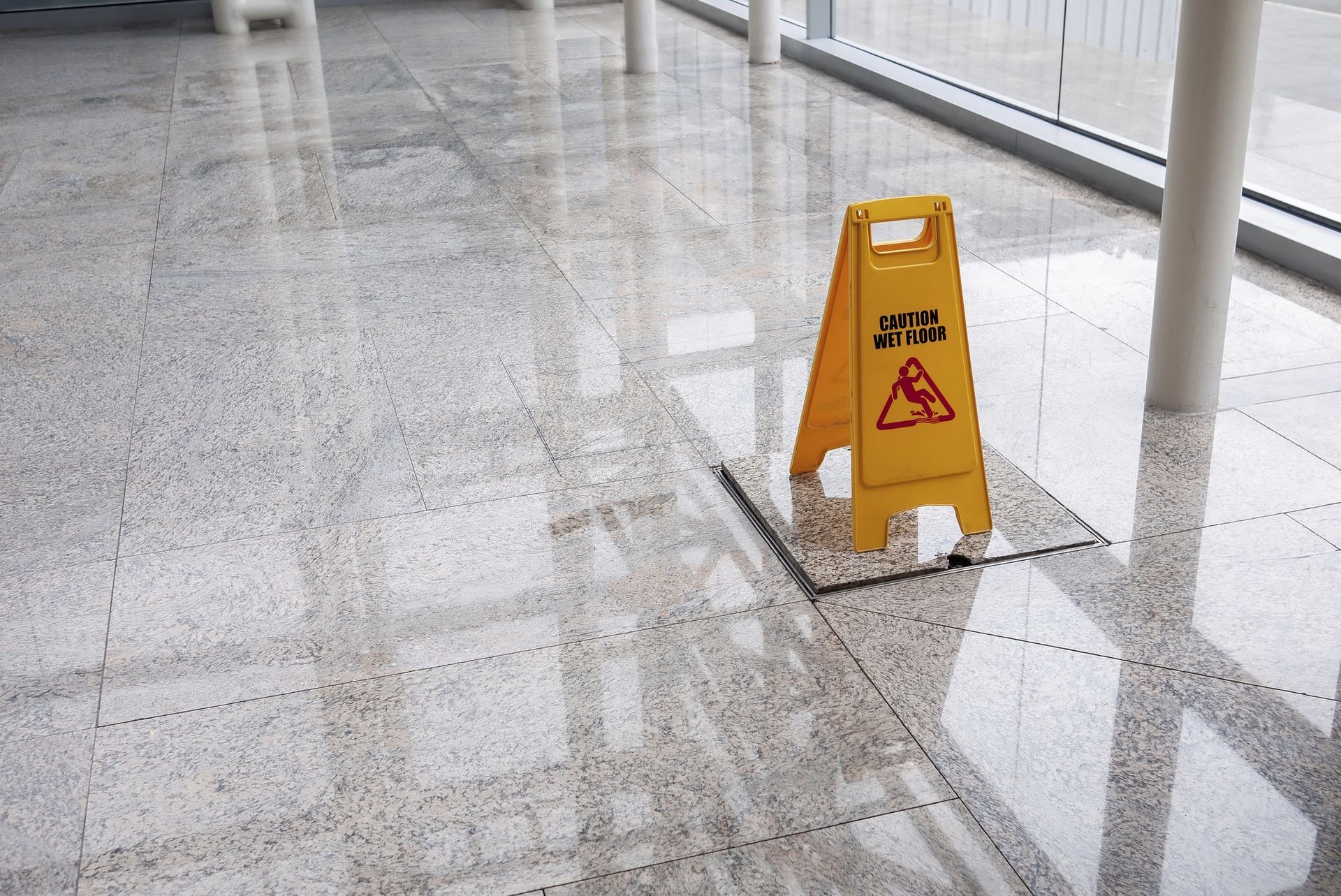 A clean tiled flooring with a caution wet floor signage.