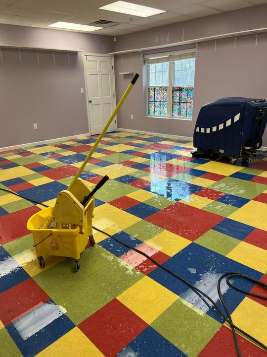 A room with a mop and bucket on the floor.