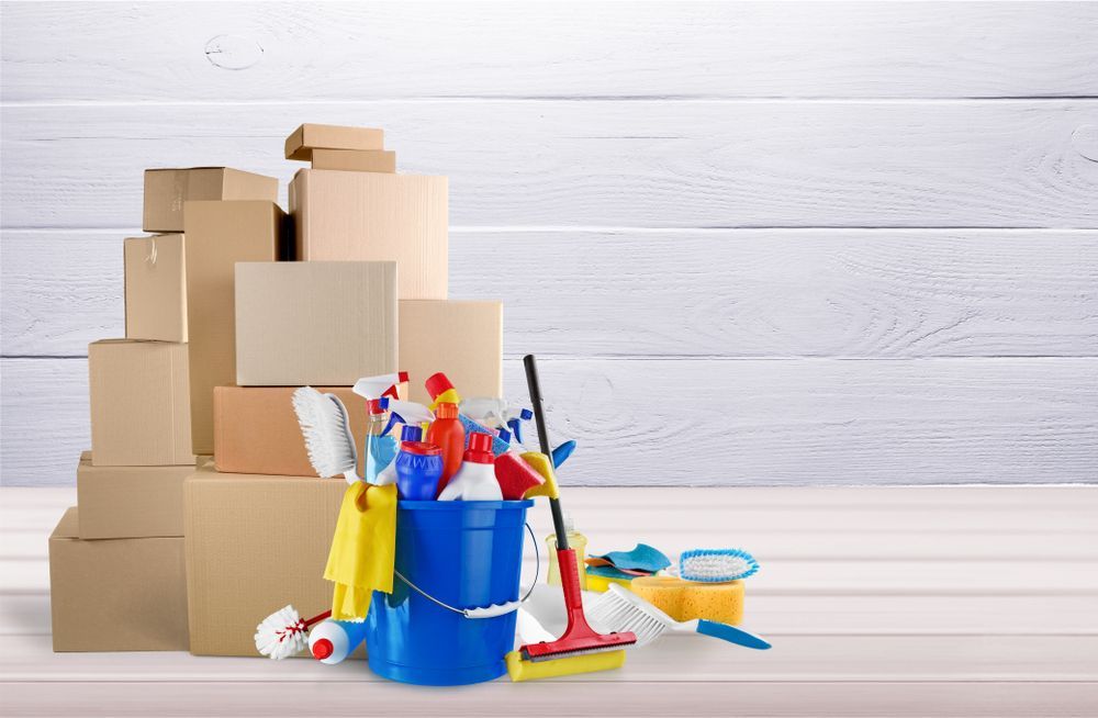 A pile of cardboard boxes and cleaning supplies.