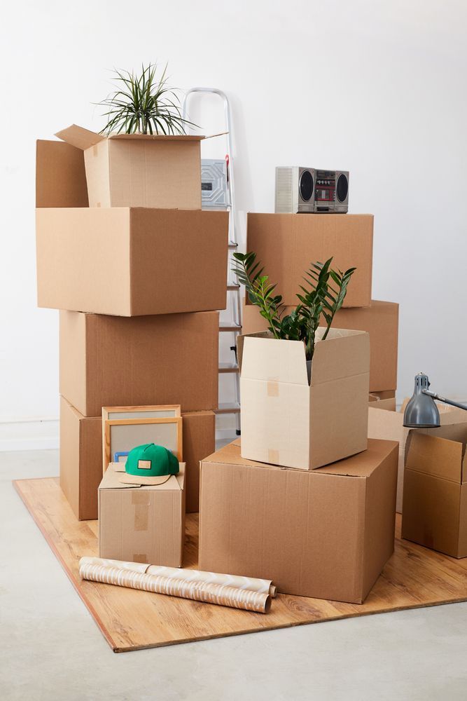 A pile of cardboard boxes stacked on top of each other in a room.