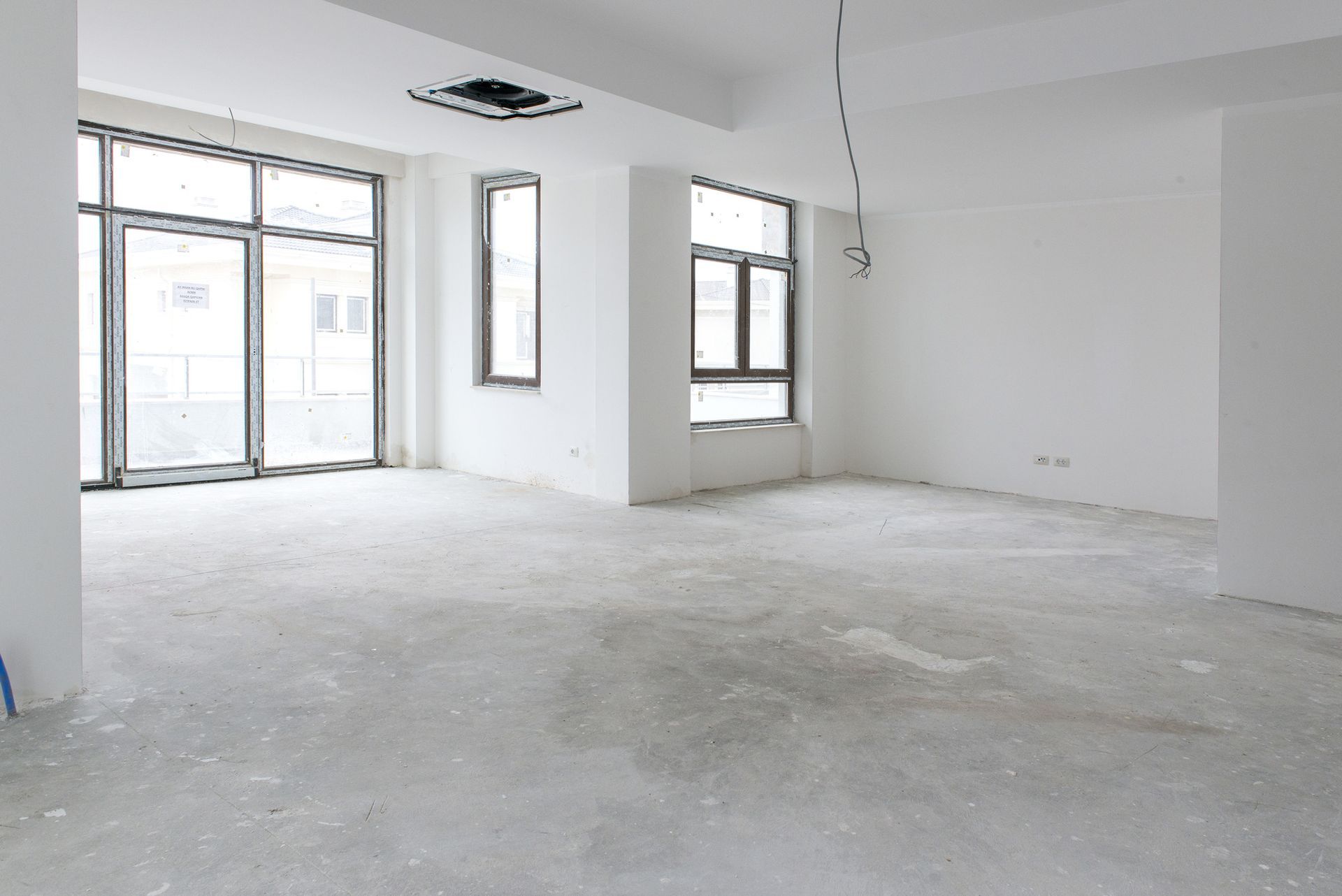An empty room with a lot of windows after construction.