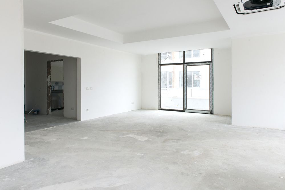 An empty room with white walls and a concrete floor.